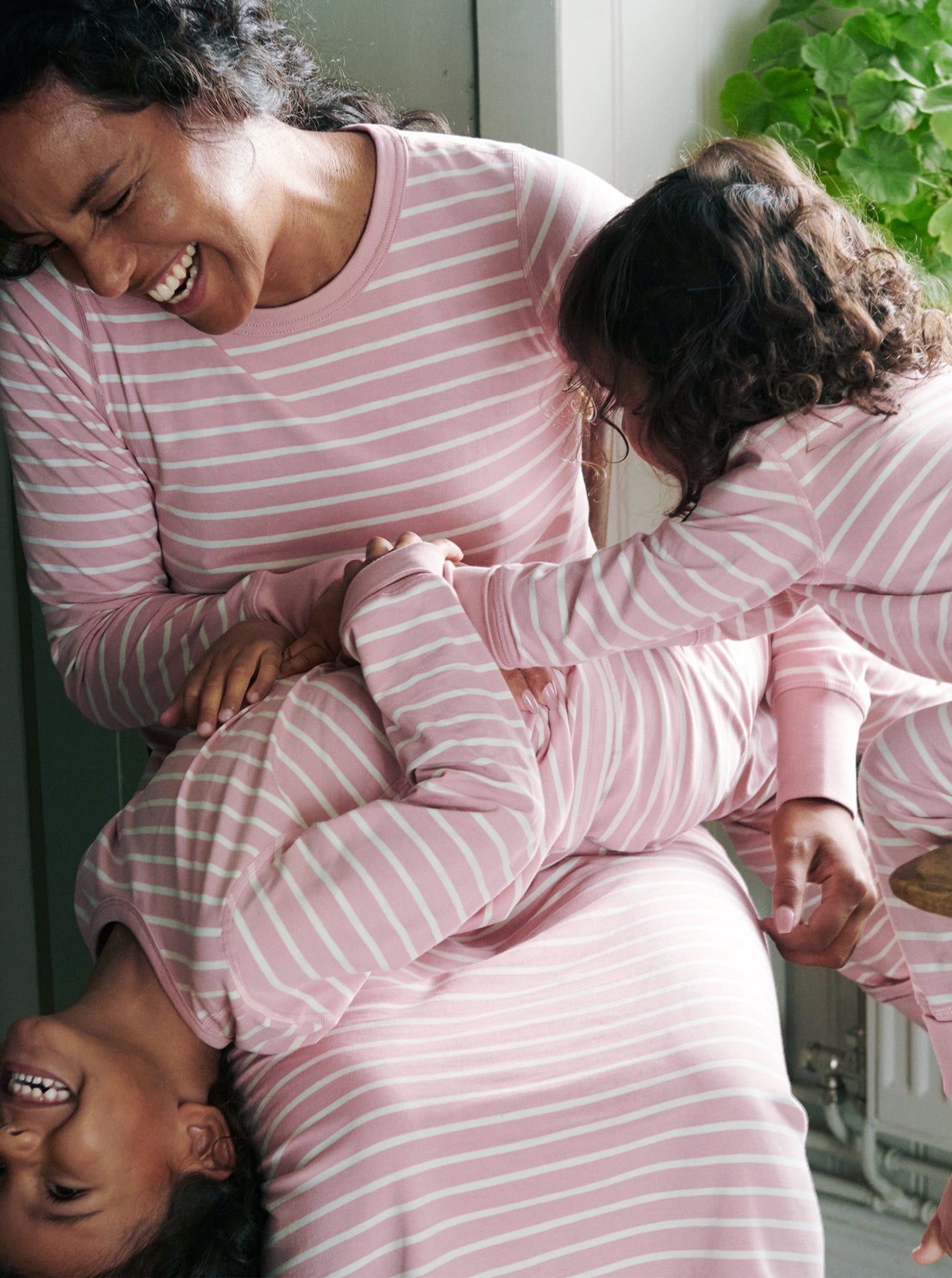 family wearing pink and white striped baby sleepsuit, organic cotton warm and comfortable, long lasting ethical clothes polarn o. pyret 