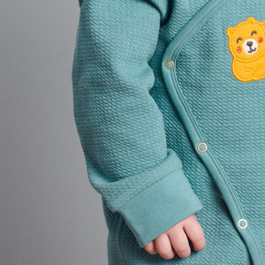 Close up of textured sleeve detail on wraparound baby onesie. Made in GOTS organic cotton with adorable sleeping bear applique