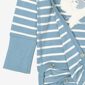 Close up of unisex blue and white striped wraparound organic cotton newborn babygrow showing wrap-over and easy popper fastening for speedy changes