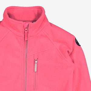 Close up shot of pink, kids waterproof fleece jacket made of breathable fabric, with reflector zip and front pocket.