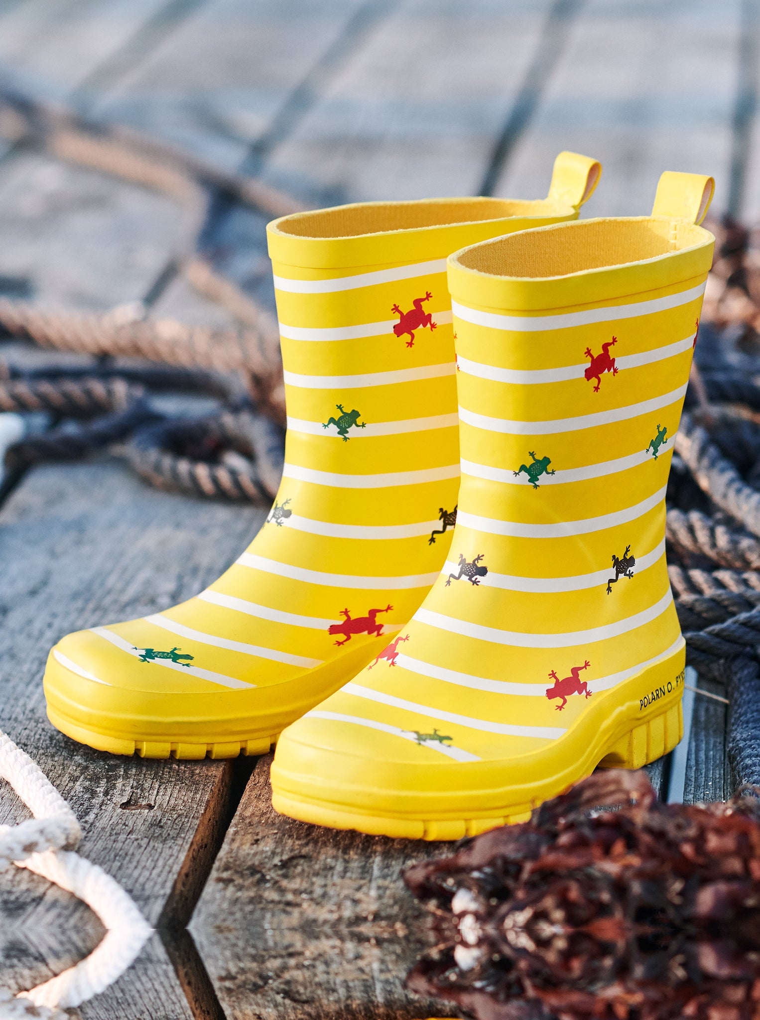 Yellow kids boots with cute frog & stripes design for rainy season, made with natural rubber and cotton for the inner lining.